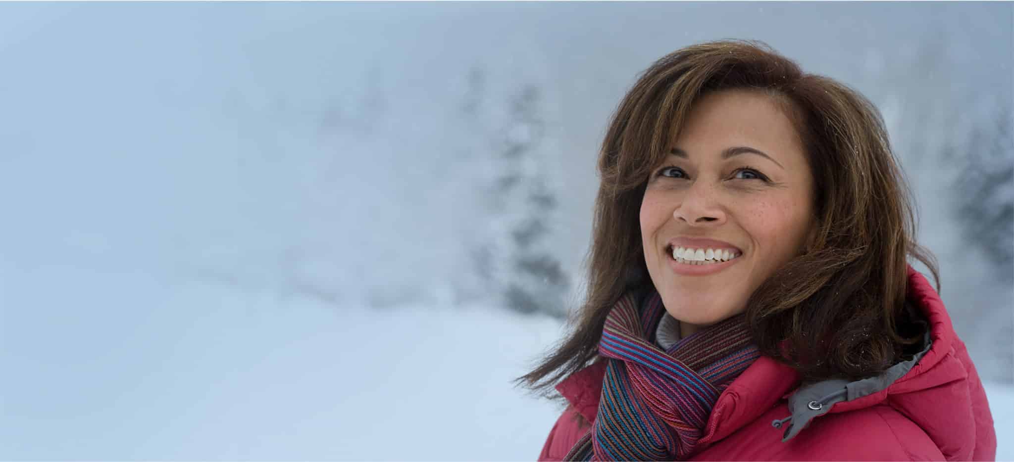 Smiling woman with a scarf in a snowstorm