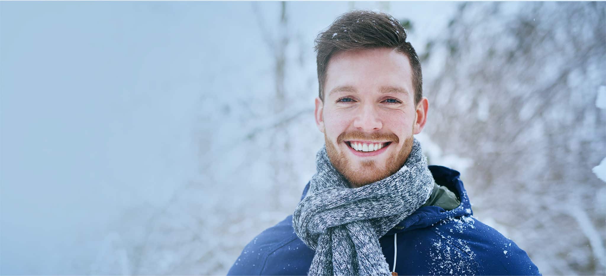 Smiling Man with a scarf in a snowfall